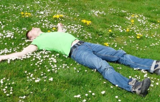 człowiek leżący na trawie