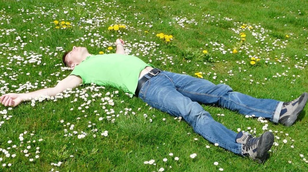 człowiek leżący na trawie